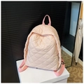 Close-up of pink quilted backpack showing diamond stitching and metal zipper detail - Pink
