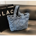 Primer plano detallado del bolso de mezclilla azul acolchado con asa de transporte ancha - Azul claro
