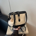 Contrast beige canvas and black leather bucket bag with gold twist lock and charm - White and Black Patchwork With Charm