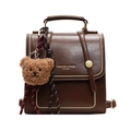 Vintage dark brown leather backpack with gold studs and a teddy bear charm on white background - With Pendant / Brown