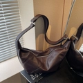 Dark brown leather croissant bag with crossbody strap and pleated details - Brown