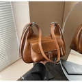 Detail of caramel vintage underarm bag with metal buckle and soft leather texture - Brown