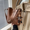 Brown leather bucket bag with retro style, wide strap, and knitted rabbit charm accessory - Brown with Pendant