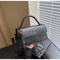 Dettaglio mini borsa squadrata in pelle nera opaca con logo dorato e tracolla regolabile - Nero