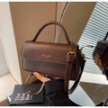 Dettaglio borsa a tracolla vintage in pelle marrone con logo dorato e manico superiore - Marrone