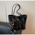 Detalle del bolso tote con estampado de mármol negro, logo triangular y colgante trenzado - Negro