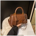 Detail of vintage brown leather handbag with gold circular twist lock and woven charm - With Charm / Brown