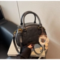 Detail view of black vintage Boston bag with gold hardware and plush bear charm - With Charm / Black