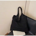 Detail of black knitted tote bag texture and straps on a leather seat - Black