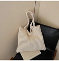 Detail of cream knit tote bag showing horizontal weave texture on a black chair - Off White