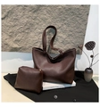 Détail du grand sac cabas en cuir marron foncé avec grain litchi sur un fond artistique - Ensemble Sac Cabas Et Pochette / Marron