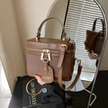 Borsa a secchiello vintage in pelle marrone con manico e tracolla davanti allo specchio - Marrone