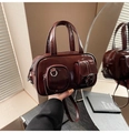 Detail of burgundy patent leather bowling bag with exterior pockets and glossy finish - Burgundy