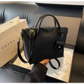 Dettaglio della borsa in nylon nero con cerniere dorate in una confezione regalo - Nero