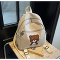 Detalle de mochila de pana con bordado de osito y colgante de cremallera de oso a juego - Blanco Roto