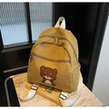 Detalle de textura de mochila de pana amarillo mostaza con bordado de oso marrón - Amarillo