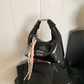 Glossy black hobo bag with silver metallic letters and a colorful woven charm - Black