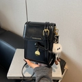 Glossy black crossbody phone bag with gold hardware and white plush monster charm - Black with Pendant