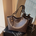 Schicke dunkelbraune Tragetasche aus Kunstleder mit Vintage-Finish und Metallanhänger - Mit Anhänger / Kaffeebraun