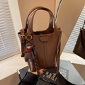 Brown bucket bag in glossy leather finish with adjustable strap and cute bear charm - Brown