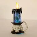 Close-up of LED Halloween candle light with melting wax, bat silhouettes and skull base - Black Cat Style