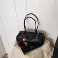 Bolso baguette negro minimalista con anillos metálicos y un llavero decorativo - Negro con colgante