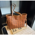 Detail of large brown tote bag with bear print pattern and golden logo on stone surface - Brown