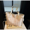 Macro view of beige tote bag with bear pattern embossing and gold brand plaque detail - Off White