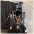 Detail der vintage dunkelgrauen Beuteltasche mit goldenem Logo und geflochtenem Anhänger - Mit Anhänger / Schwarz