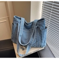 Détail d'un grand sac fourre-tout en denim bleu clair avec plusieurs poches extérieures - Bleu Denim