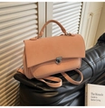 Detalle macro de bolso de cuero mate rosa palo con cierre plateado sobre fondo texturizado - Rosa