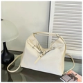 Detail of cream white leather tote bag featuring decorative straps and silver metal buckles - White