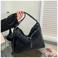Detailed view of large black leather hobo bag with buckled strap and lychee grain texture - Black