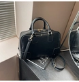 Detalle de un bolso Boston negro con cremalleras doradas dobles y asas redondeadas - Negro