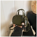 Detailed shot of olive green leather boston bag with unique cartoon pendant and shoulder strap - Green with Pendant