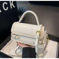 Détail d'un sac à main en cuir grainé crème avec boucle dorée dans son coffret cadeau - Blanc Cassé
