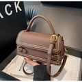 Détail du sac à main en cuir grainé marron foncé avec rivets dorés et fermoir en métal - café