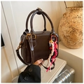 Close-up of brown Boston bag showing contrast stitching and colorful braided charm - Coffee with Pendant