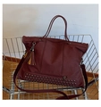 Dettaglio della borsa tote bordeaux con borchie e nappina in un carrello della spesa - Borgogna