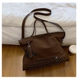 Dettaglio della borsa tote marrone con nappe in pelle e borchie metalliche decorative - Marrone