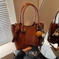 Bolso tipo cubo vintage marrón de piel sintética con asas dobles y colgante de béisbol - Marrón con colgante