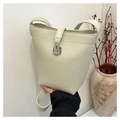 Detail of lychee pattern leather bucket bag with silver metal swivel lock and strap - Off White