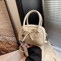 Sac bowling chic en cuir crème avec un nœud en cuir et des détails de breloque coeur - Blanc avec pendentif