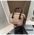 Gros plan détaillé du tissu tressé crème et de la poignée en cuir marron foncé du sac - Marron