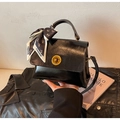 Detalle de bolso negro con cierre giratorio dorado y bufanda de seda decorativa con osos - Talla única / Negro