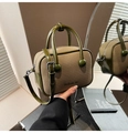 Détails d'un sac Boston bicolore en cuir verni vert olive avec une texture tissée - Vert
