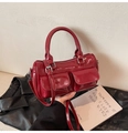 Detail der burgunderroten Lackleder-Bowlingtasche mit Vordertaschen und Silberbeschlägen - Einheitsgröße / Rot