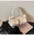 Detail einer cremefarbenen Boston Bag mit silbernen Beschlägen und zwei Vordertaschen - Einheitsgröße / Weiß