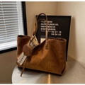 Detailed view of brown suede tote bag with quilted pattern and small round coin purse charm - Brown