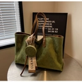 Detail of dark green suede tote bag with quilted diamond pattern and a small coin purse - Green